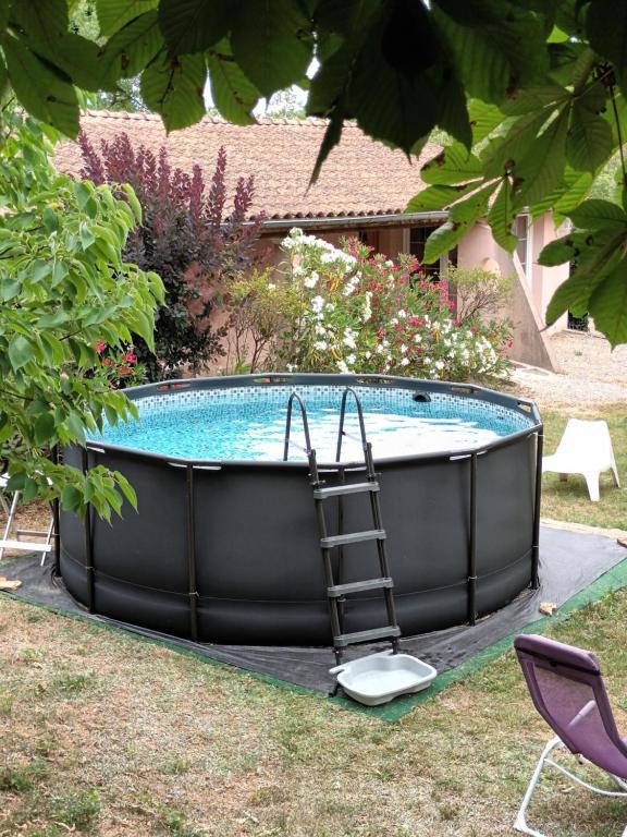 a hot tub with a ladder next to a yard at Les Murmures de la Forêt Bed and Breakfast in Lanas