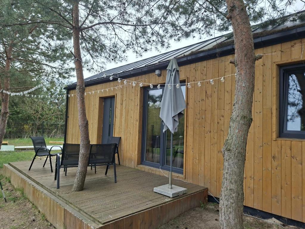 a cabin with a table and chairs on a wooden deck at Rzeczny azyl in Pomiechówek