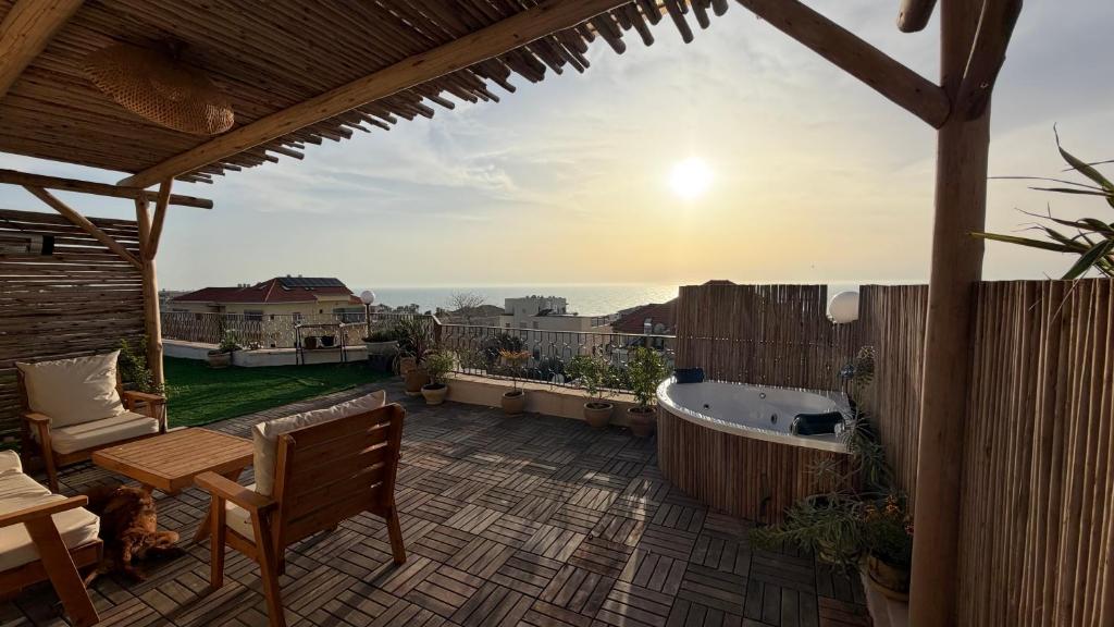 a patio with a tub and a bench on a deck at The Jaffa Roof in Tel Aviv