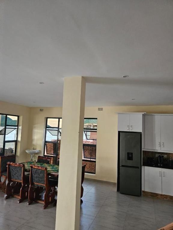 a kitchen and dining room with a table and a refrigerator at Nyanja Cottage in Chembe