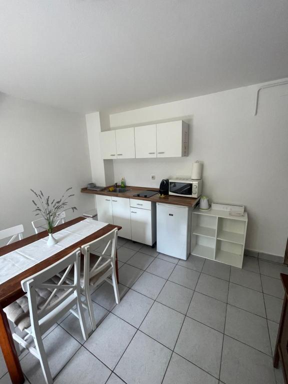 a kitchen with white cabinets and a table in it at Apartment Klementina FREE PARKING in Zagreb
