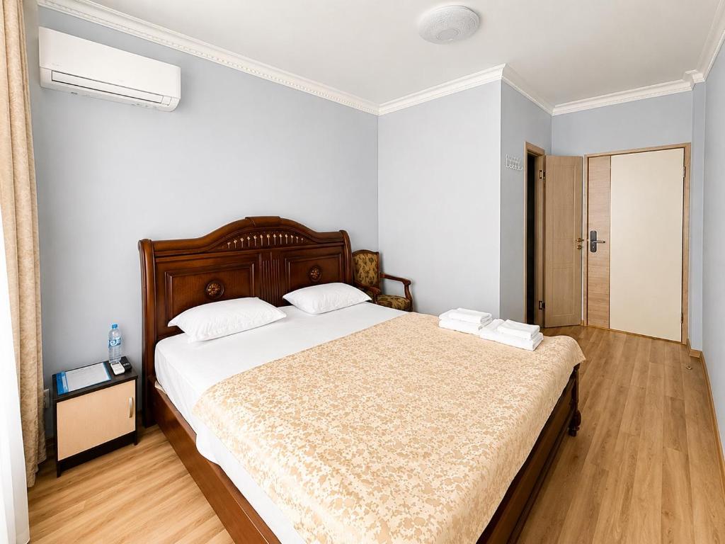 a bedroom with a large bed with white sheets at Mini Hotel "Arystan" в самом центре столицы in Astana