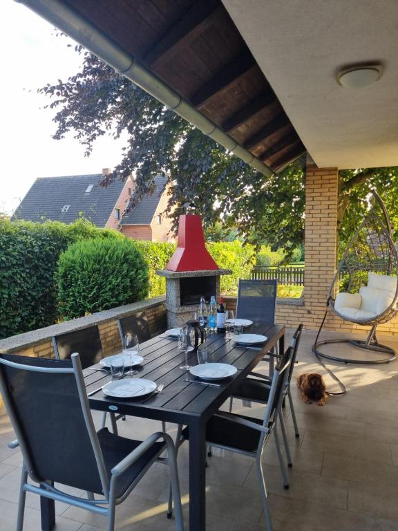 a table and chairs on a patio with a fireplace at Robbenglück Tossens - Ruhe, Garten und Nordseegefühl in Tossens