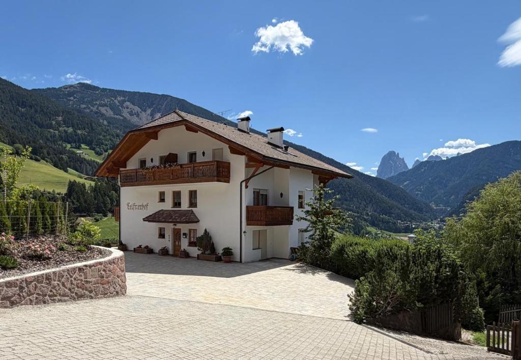 a large white house with mountains in the background at Nature Residence Telfnerhof in Laion