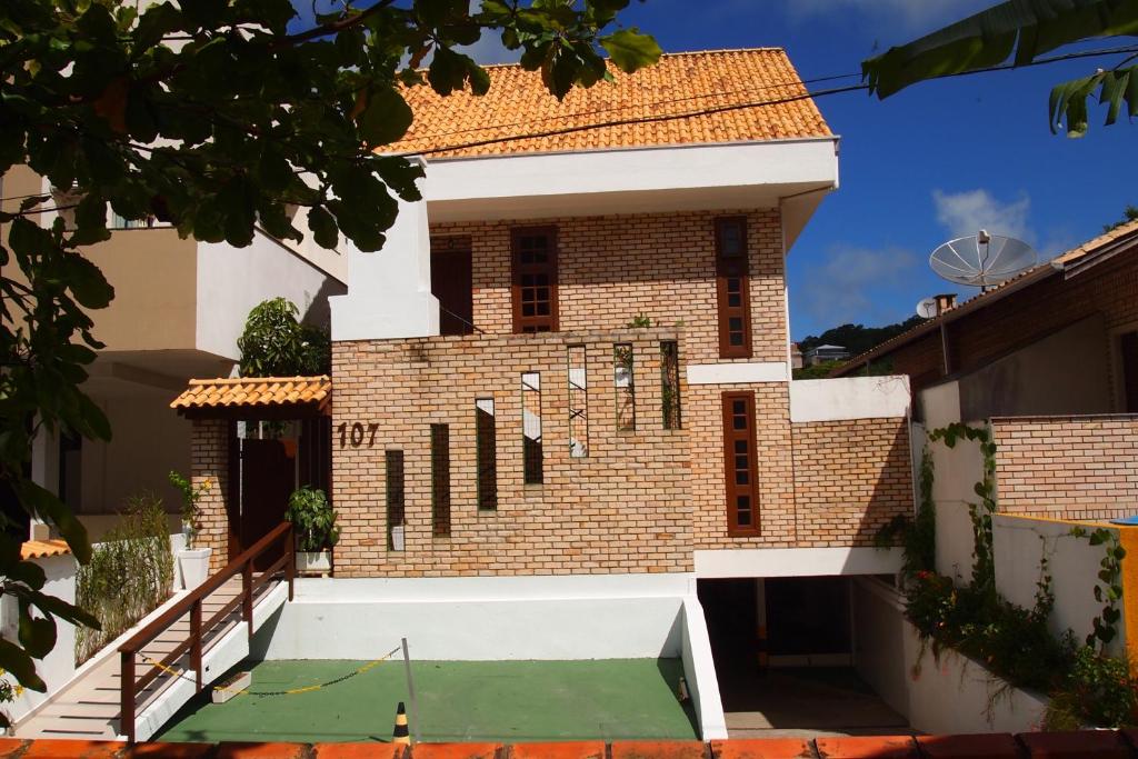 a house with a tennis court in the courtyard at Apartamentos Morada do Canto - 130m da praia principal Bombinhas in Bombinhas