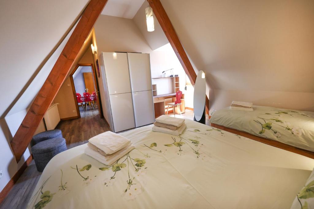 a attic bedroom with two beds and a kitchen at Gîte sous le toit du vigneron in Epfig