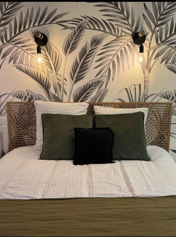a bedroom with a bed with a plant wall at Le Nid douillet- Studio Chic au cœur Issoire in Issoire