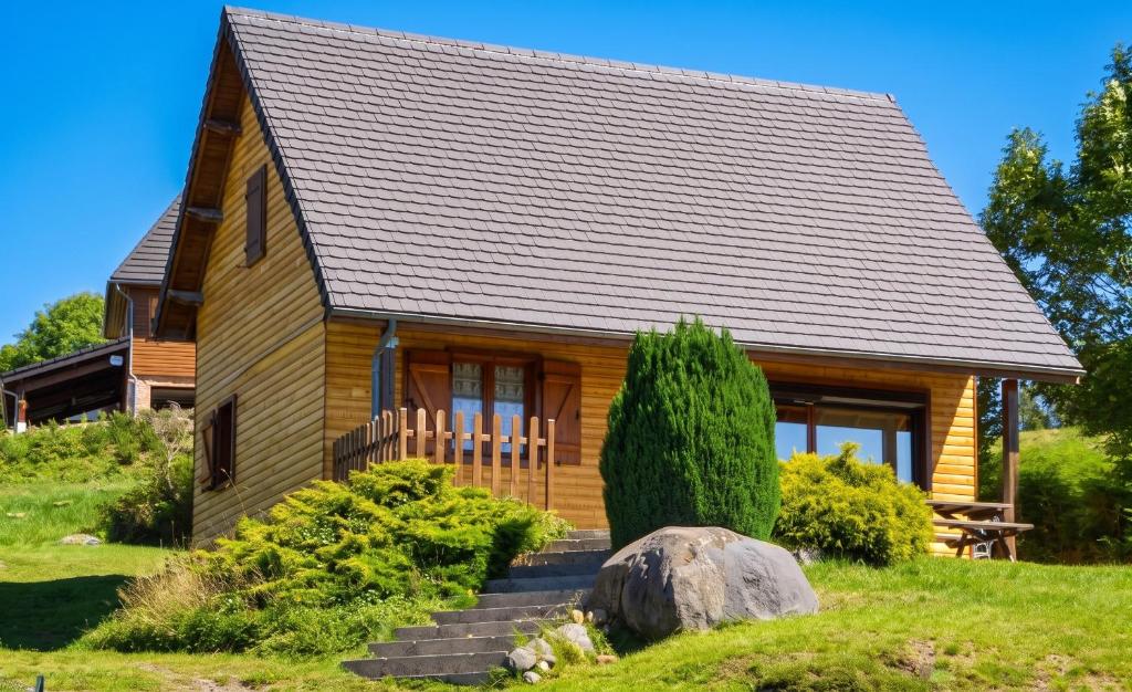 a log cabin with a staircase in front of it at Chalet charmant à Saint-Gènes-Champespe avec parking privé in Saint-Genès-Champespe