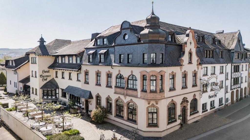 ein großes weißes Gebäude mit schwarzem Dach in der Unterkunft Eurener Hof in Trier