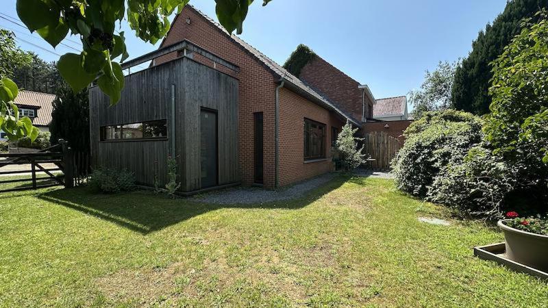 a brick house with a yard with a grass yard at Hooiland's Hof in Diest