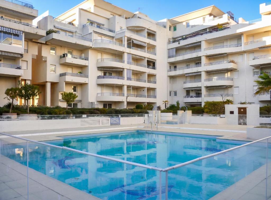 a swimming pool in front of a building at Appartement moderne à Fréjus, 60 m², piscine partagée in Fréjus