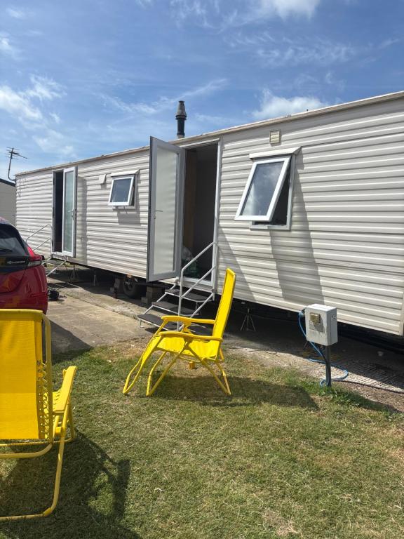a group of yellow chairs in front of a trailer at 159 cambersands in Hastings
