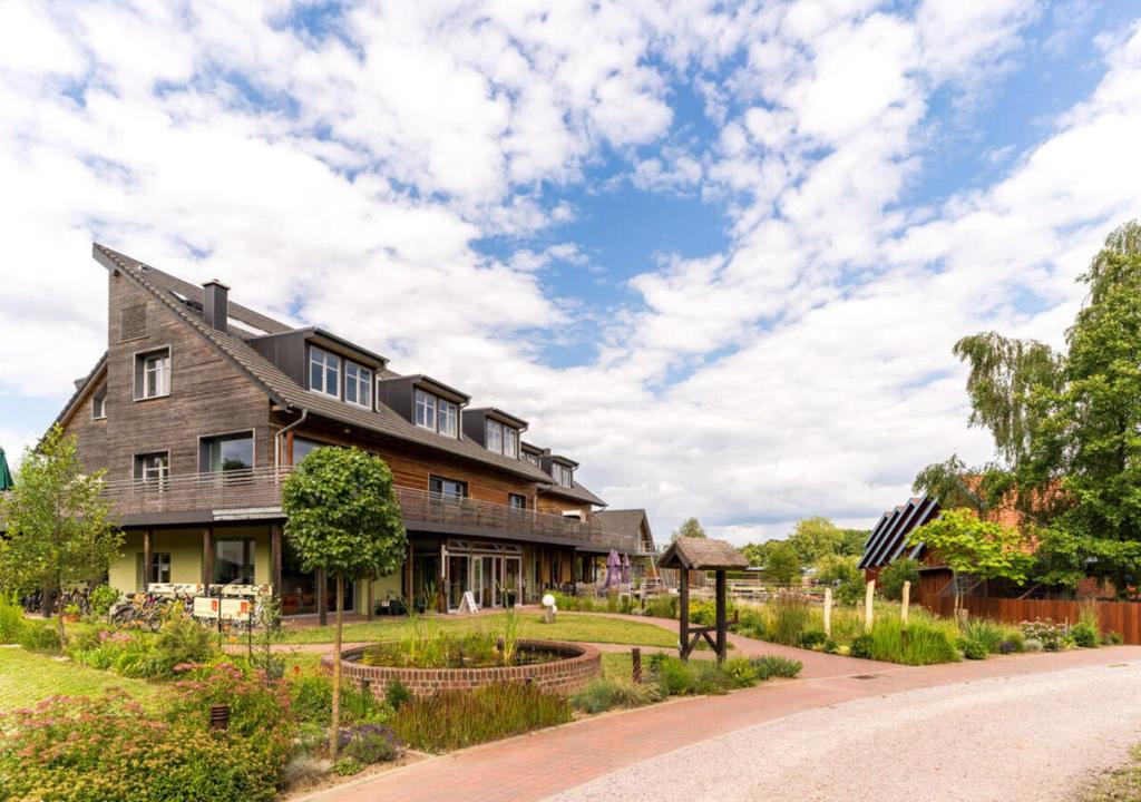 a house on a dirt road next to a yard at An der Metow-Ferienpark Hotel in Plau am See
