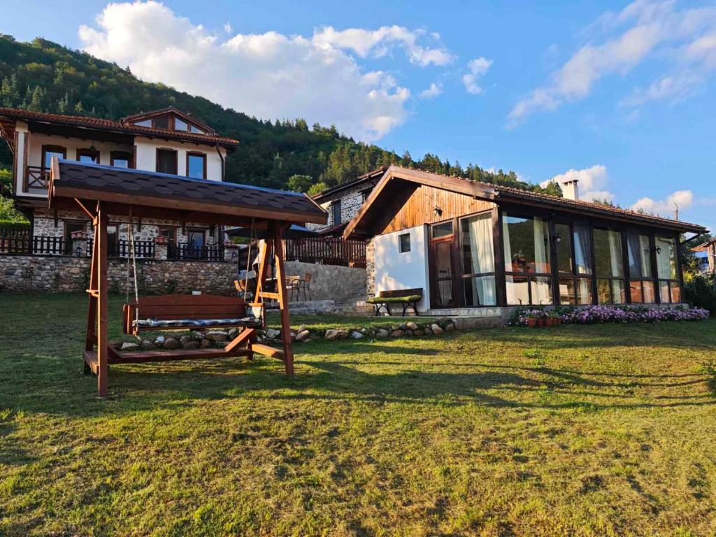 a house with a bench in front of a house at Villa Vera in Smilyan