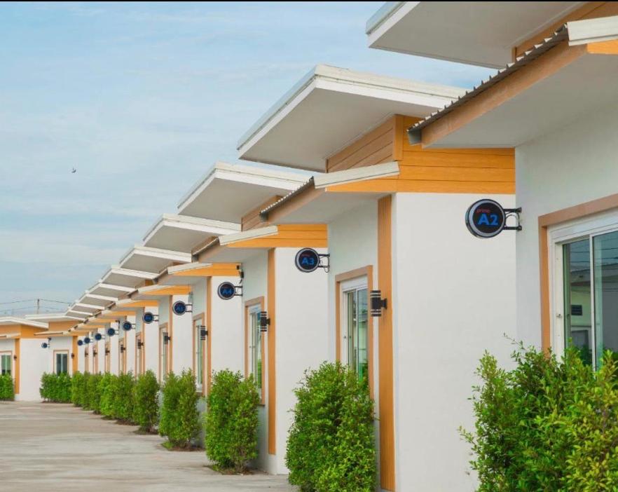 a row of white buildings with plants in front at โรงแรม นีโอ รีสอร์ท in Ban Thap Nang