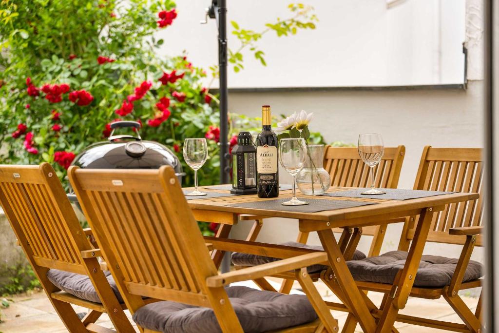 ein Holztisch mit Weinflaschen und Gläsern darauf in der Unterkunft MOLA Apartments-Stilvolle Altstadtwohnung- Seilersee-5 Personen-Terrasse-Grill-Gratis WLAN in Iserlohn