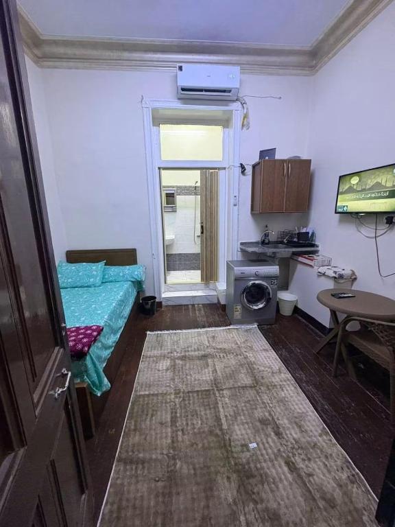a small room with a bed and a table at Adel home in Kafr al Ishārah