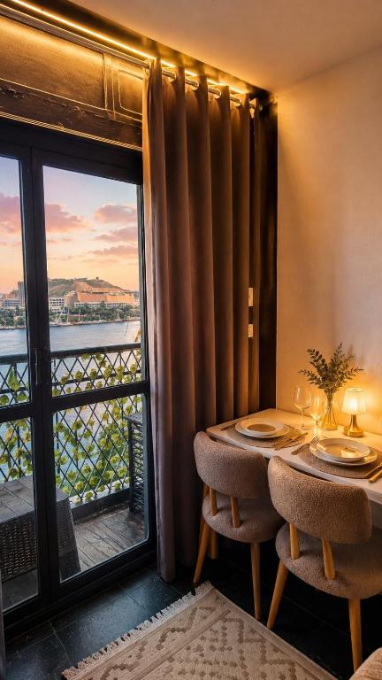 a dining room with a table and a window with a view at Aswan sunrise in Aswan