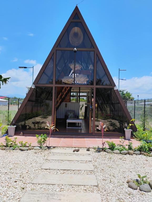 a building with a triangular roof on a beach at A-frame cabin in Parrita