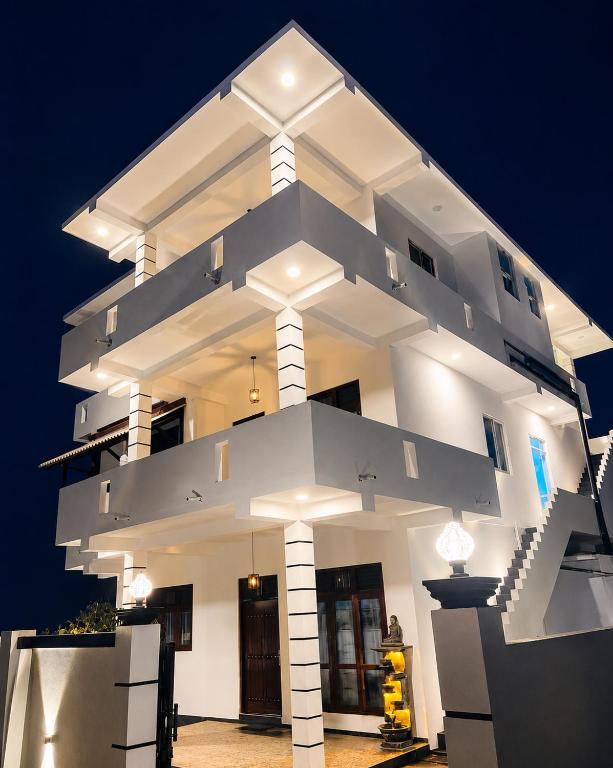 a large white building with lights on it at night at Blue Waves Ocean Mirissa in Mirissa