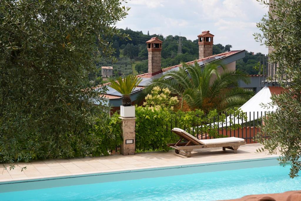 a swimming pool with a bench next to a house at Villino con piscina in Terni