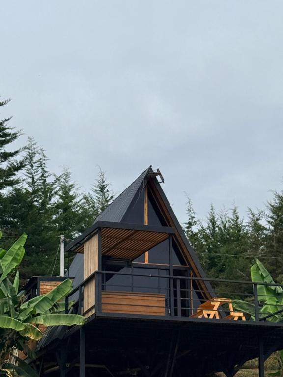 a small cabin with a black roof on a tree at Cabaña Con Jacuzzi Privado y Vista a La Montaña in Guarne
