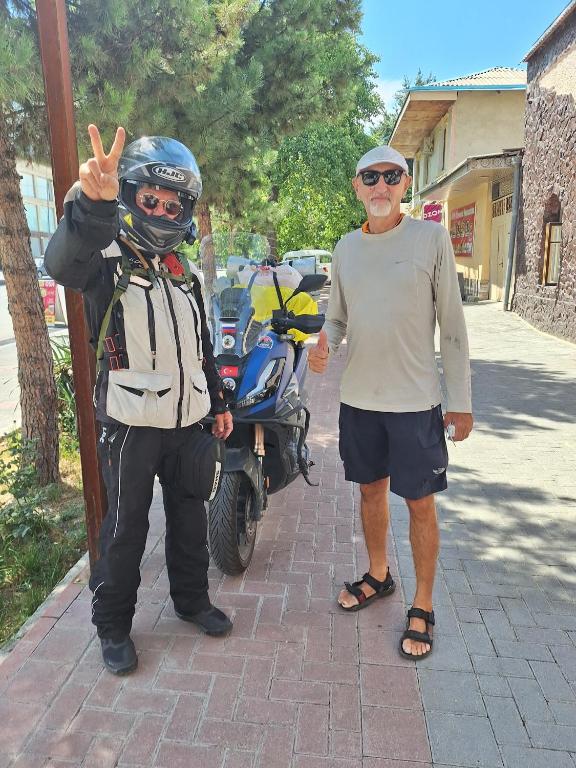 a man standing next to a man in front of a motorcycle at Dom Hostel in Samarkand