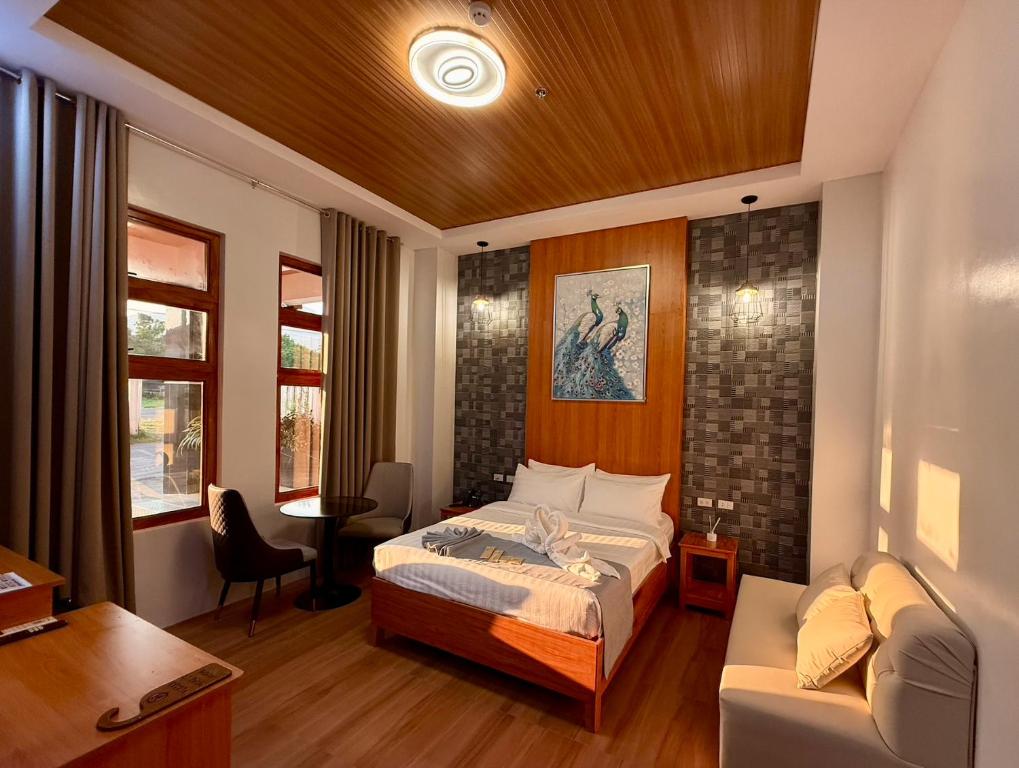 a bedroom with a bed and a desk and a couch at MBC Hotel in Guinlajong