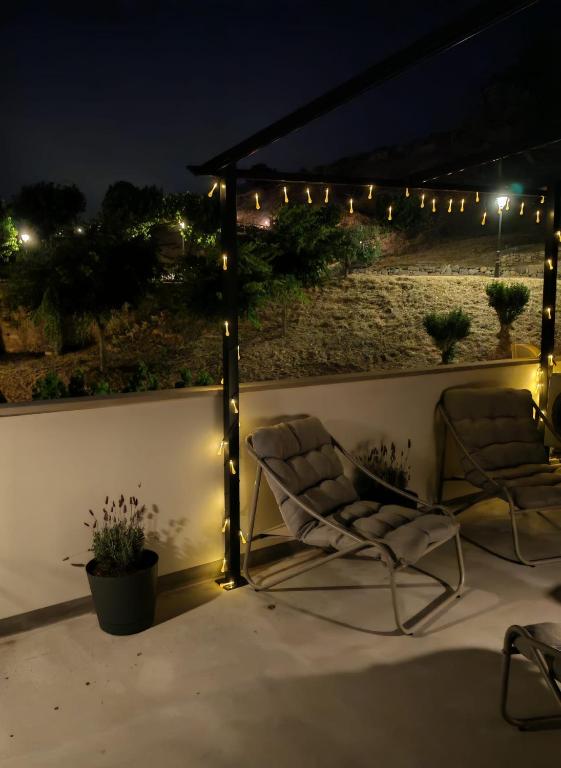 zwei Stühle auf einer Terrasse bei Nacht mit Lichtern in der Unterkunft Ca l'Eli Caseta in Montblanc
