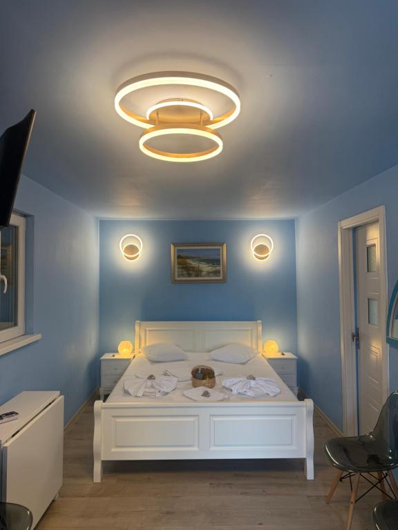 a bedroom with a white bed with a blue wall at Studio Bucuria Corbu in Corbu