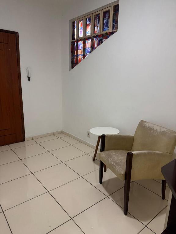 a living room with a chair and a table at Apartamento individual in Ipatinga