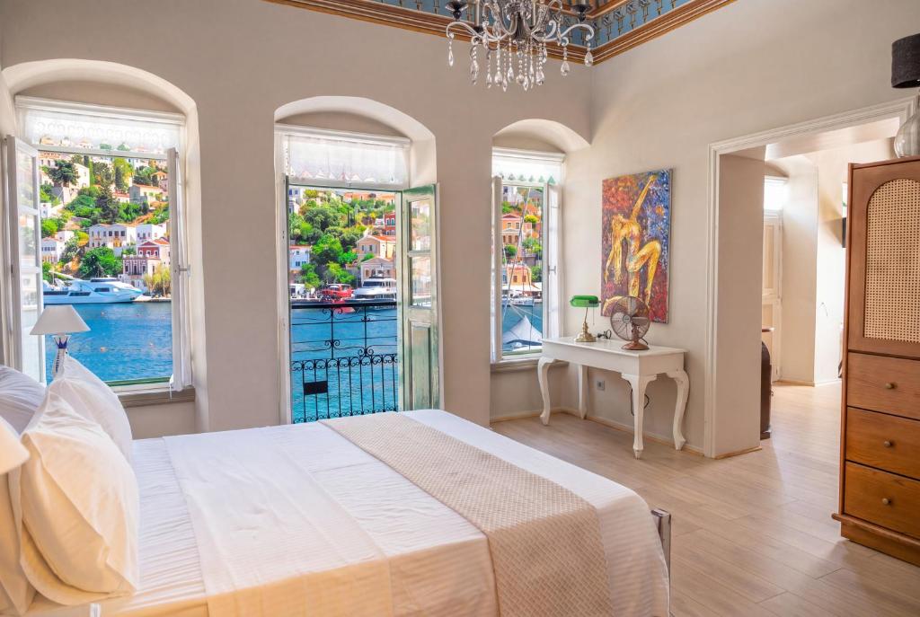 a bedroom with a large white bed and windows at "LOS" 1 Neoclassic Harbour View in Symi