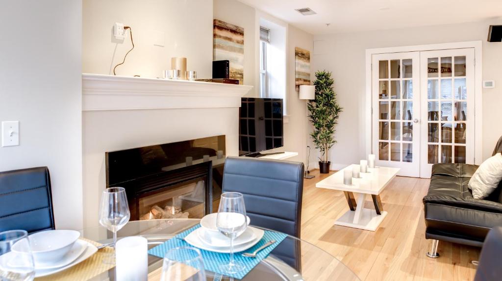 a living room with a fireplace and a table and chairs at Fully Furnished Apartment in Washington near Logan Circle in Washington, D.C.