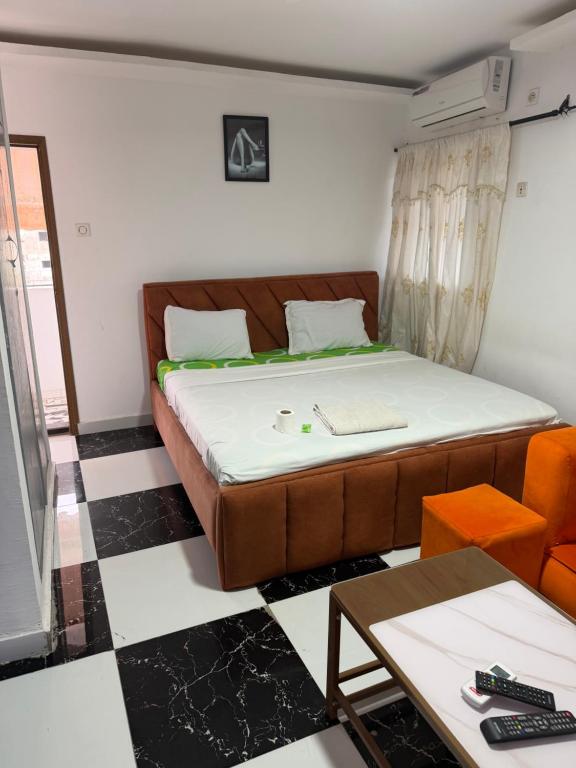 a small room with a bed and a table at Residence Singa in Abidjan