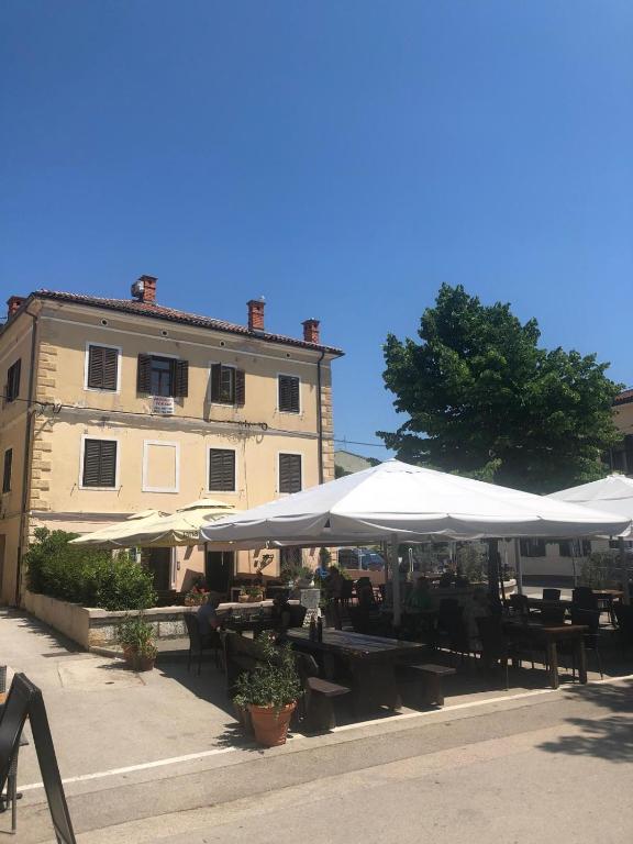 a restaurant with tables and umbrellas in front of a building at Summer Home No. 8 in Fažana
