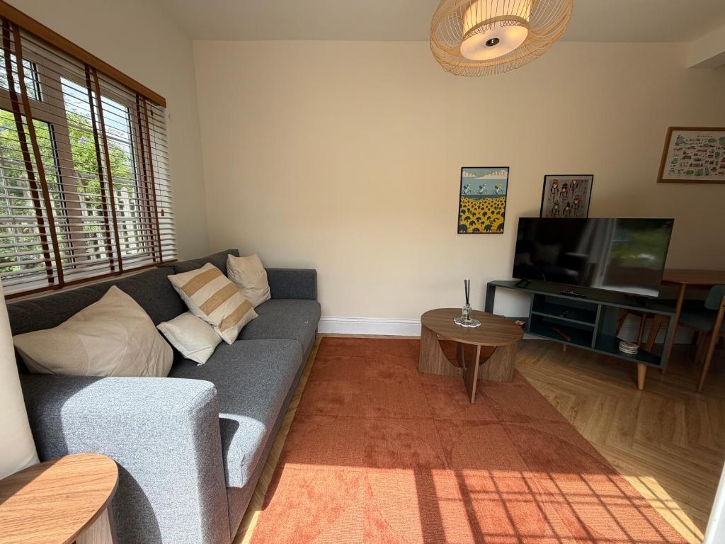 a living room with a couch and a television at Peaceful Self-Contained Apartment in Beckenham