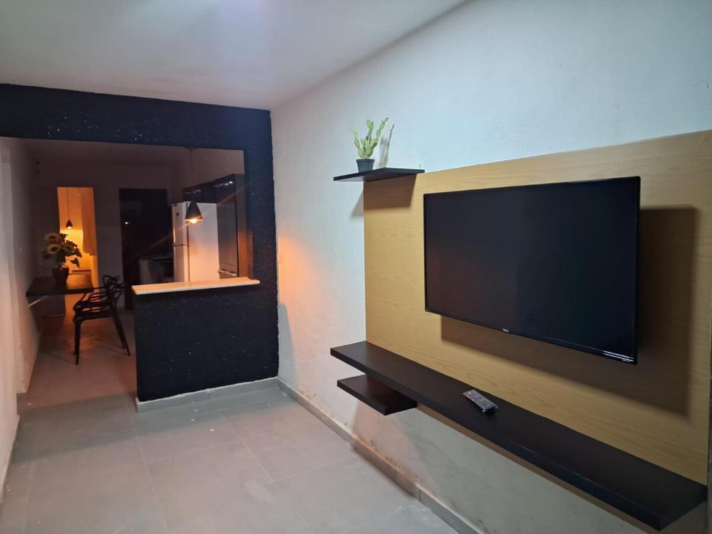 a living room with a large flat screen tv on a wall at espaço completo só para você e seus familiares in Gravatá
