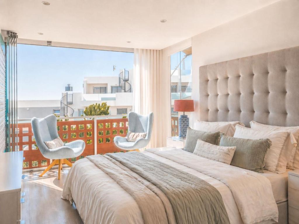a bedroom with a large bed and a large window at RenTenerife Elim Ocean in La Tejita