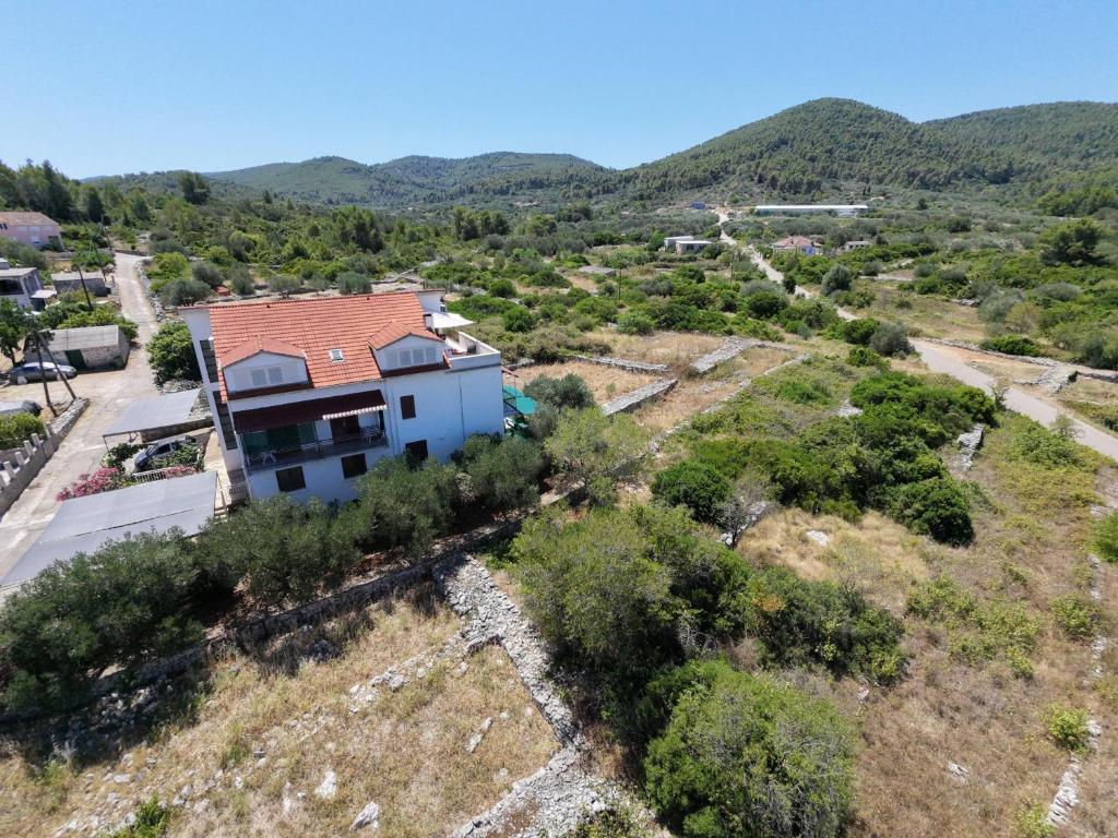 an aerial view of a house with mountains in the background at Protić Apartments in Vela Luka