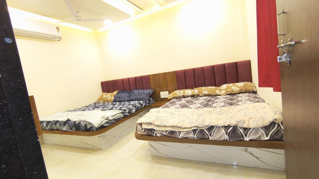 two beds in a small room withthritisthritisthritisthritisthritisthritisthritisthritisthritis at Hotel shivansh in Godarpura