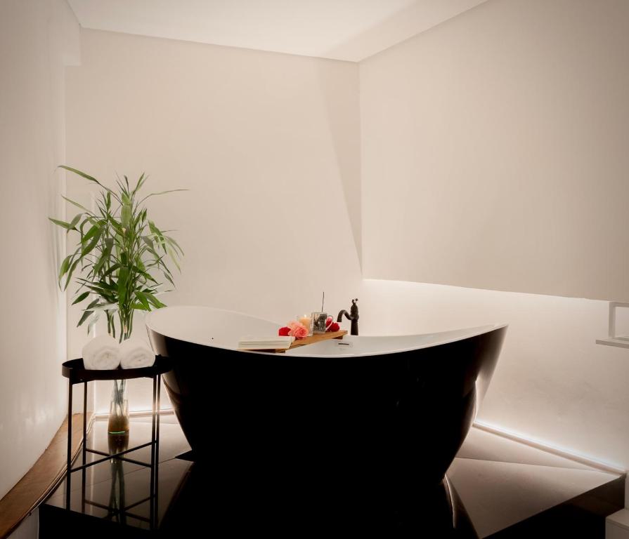 a white room with a white tub in the corner at Estúdio 196 in Bento Gonçalves
