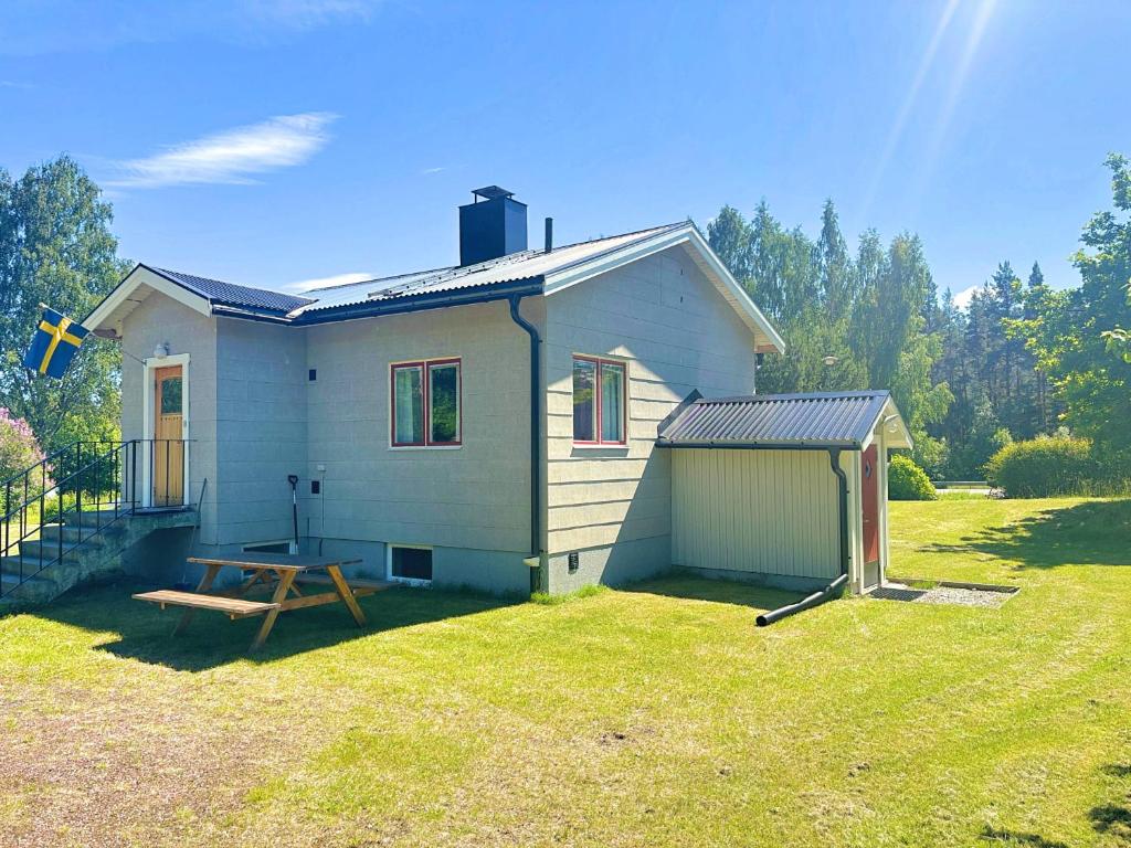 a small house with a picnic table in a yard at Hus Indalsälven in Hammarstrand