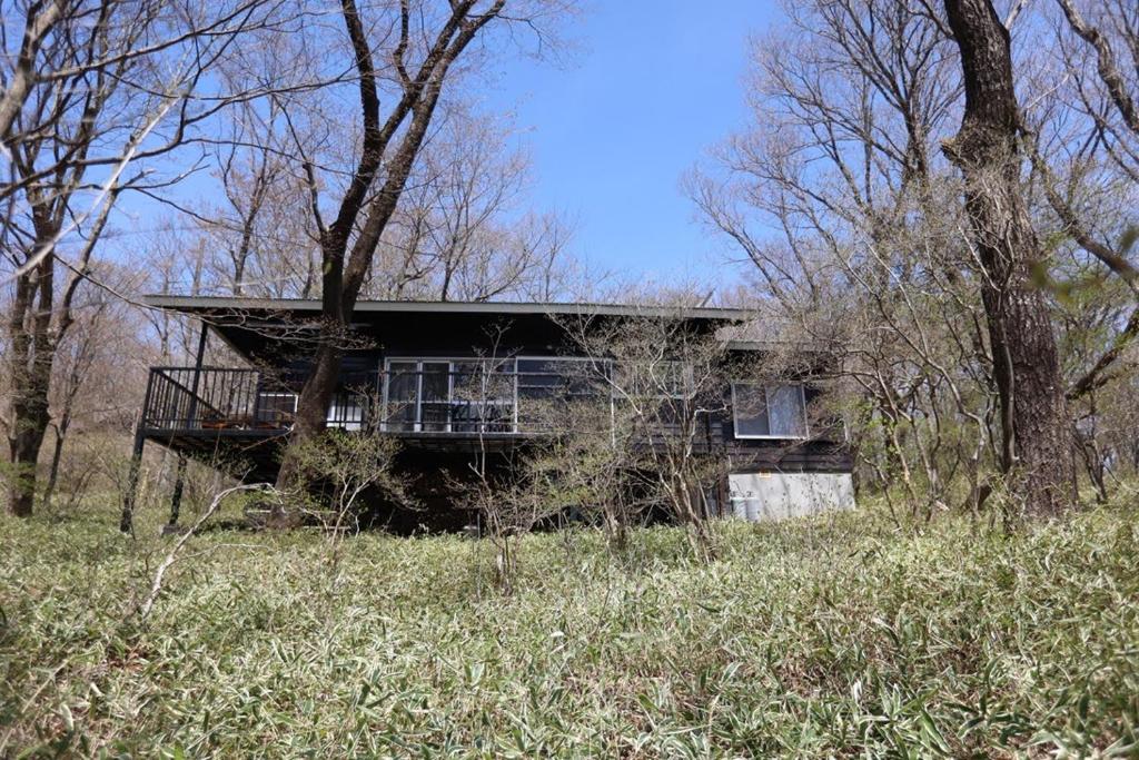 a house sitting on a hill in the woods at 木漏れ日の森で都会では味わえない静寂を那須の自然を満喫する貸別荘つつじ山 in Nasu
