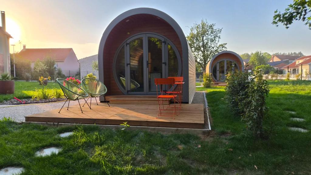 a tiny house with chairs and a table on a deck at Les Lodges de la Moivre in Saint-Jean-sur-Moivre