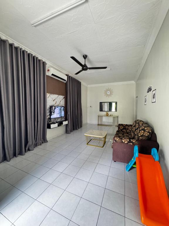 a living room with a couch and a tv at LOT 1423 Homestay Lonek-Batu Kikir in Bahau