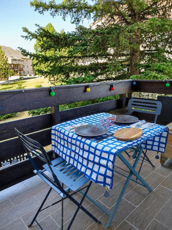 a blue and white table and chairs on a patio at Appartement 4 couchages avec terrasse in Ancelle