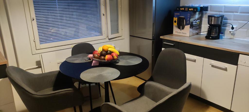 eine Küche mit einem Tisch, auf dem eine Obstschale steht in der Unterkunft Multsu apartment in Tampere