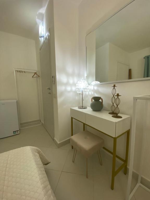 a white room with a dressing table and a mirror at Amore di Mare in Cagliari