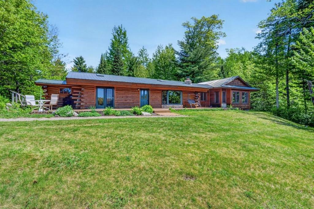 a log cabin with a lawn in front of it at Lang Lodge cabin in Drummond