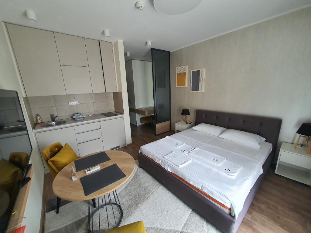 a small bedroom with a bed and a table at Omega Dom in Vrnjačka Banja